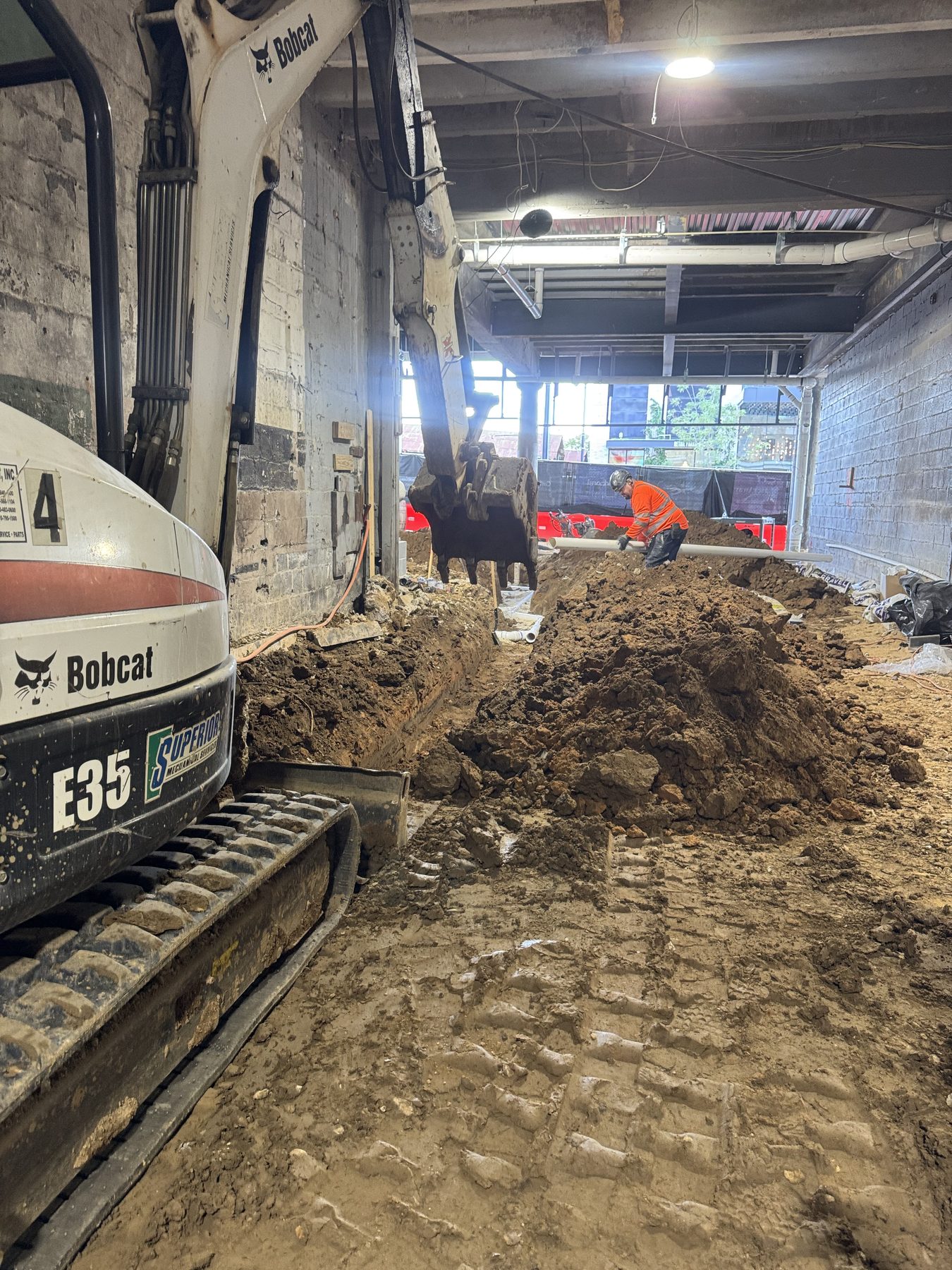 Mini excavator trenching inside a commercial building